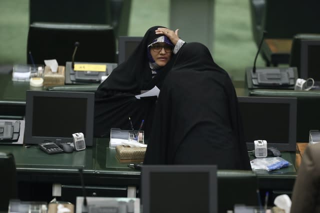 A politician adjusts her veil as she talks with a colleague (Vahid Salemi/AP)