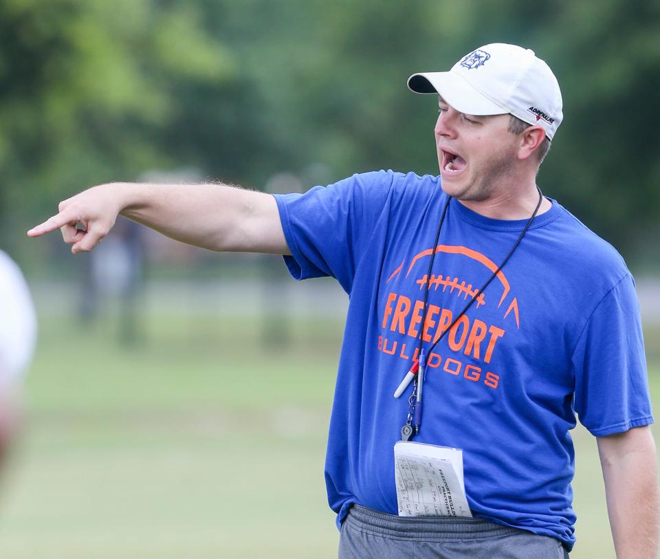 Head coach Shaun Arntz gives directions to his team during a Freeport Bulldogs summer football practice.