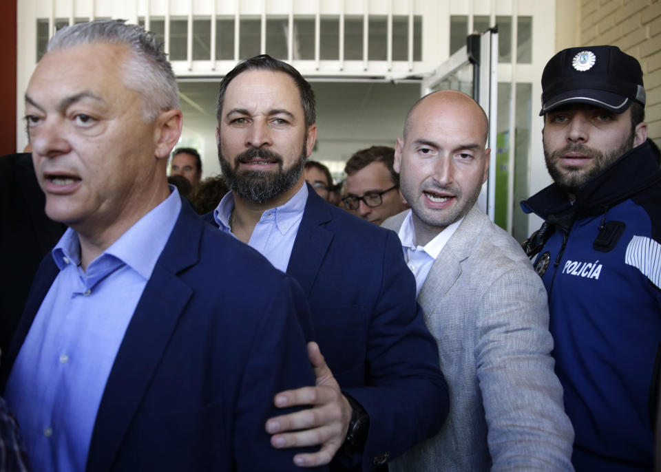 Santiago Abascal, center left, leader of far right party Vox, leaves a polling station after voting in Spain's general election in Madrid, Sunday, April 28, 2019. Galvanized by the Catalan crisis, Spain's far right is set to enter Parliament for the first time in decades while the Socialist government tries to cling on to power in Spain's third election in four years. (AP Photo/Andrea Comas)