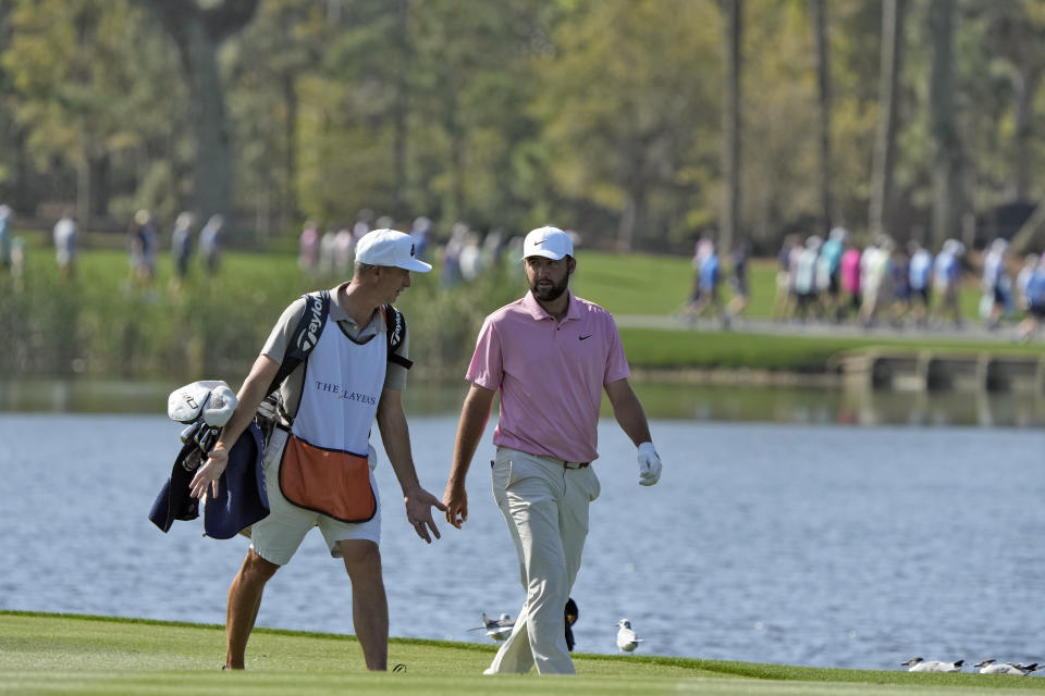 Scottie Scheffler, right, walks with his caddy along the 18th fairway during the second round of The Players Championship golf tournament Friday, March 15, 2024, in Ponte Vedra Beach, Fla. (AP Photo/Lynne Sladky)