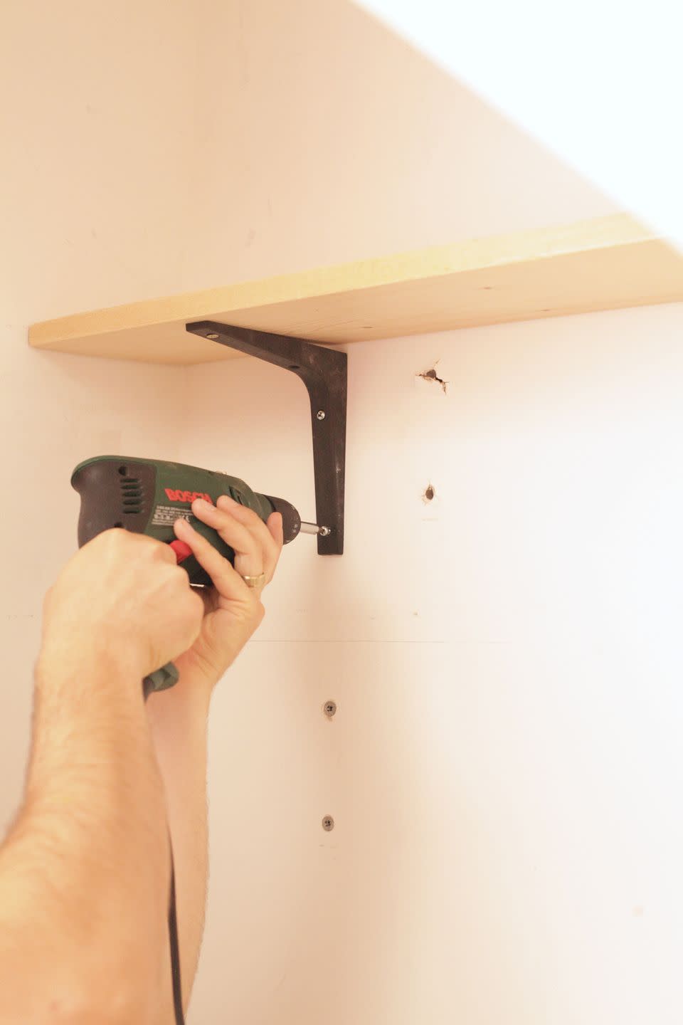 <p>Once your base is dry, mark out the height of your shelves and drill in your brackets – watch our for wires, and a spirit level is always useful (you can use the <a href="https://apps.apple.com/gb/app/bubble-level-for-iphone/id465613917" rel="nofollow noopener" target="_blank" data-ylk="slk:Bubble Level iPhone app from the App Store;elm:context_link;itc:0;sec:content-canvas" class="link ">Bubble Level iPhone app from the App Store</a>.) Don't add your shelves just yet. </p>