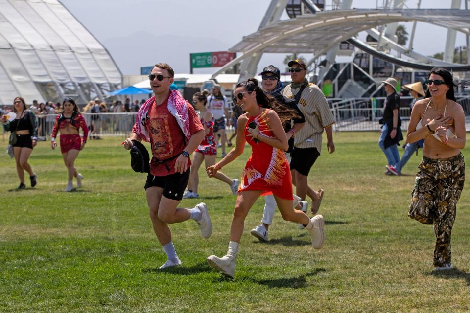 Festivalgoers run to the merchandise booth after gates open at the Empire Polo Club during the Coachella Valley Music and Arts Festival in Indio, Calif., on Friday, April 14, 2023. 