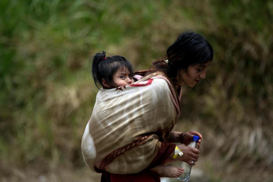 An Ecuadorian migrant carries her daughter through the jungle of the Darién Gap last month.