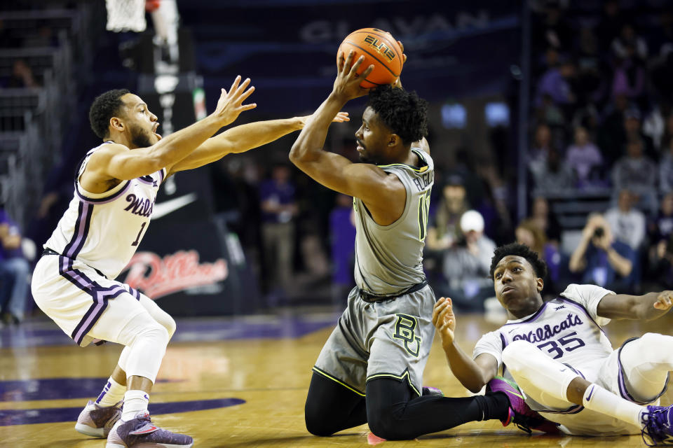 Baylor guard Adam Flagler (10) attempts to pass after grabbing a loose ball as Kansas State's Markquis Nowell (1) and Nae'Qwan Tomlin (35) defend during the first half of an NCAA college basketball game, Tuesday, Feb. 21, 2023, in Manhattan, Kan. (AP Photo/Colin E. Braley)