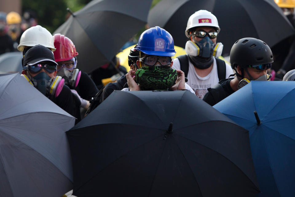 Protesters take cover behind umbrellas as police fire tear gas at them in Wong Tai Sin during a general strike in Hong Kong on August 5, 2019, as simultaneous rallies were held across seven districts. - Hong Kong riot police clashed with pro-democracy protesters for a third straight day on August 5 as the city's leader warned the global financial hub was nearing a "very dangerous situation", and a rare strike caused transport chaos. (Photo by Isaac LAWRENCE / AFP)        (Photo credit should read ISAAC LAWRENCE/AFP/Getty Images)