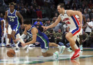 Dallas Mavericks guard Josh Green, front left, dives for the ball against Detroit Pistons forward Bojan Bogdanovic (44) in the second half of an NBA basketball game Monday, Jan. 30, 2023, in Dallas. (AP Photo/Richard W. Rodriguez)