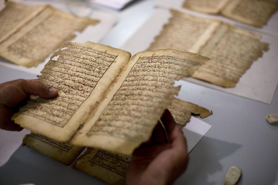 In this photo taken on Monday, Jan. 27, 2014, an employee works on a restoration of an old manuscript at the al-Aqsa mosque compound library in Jerusalem. The library has a collection of some 4,000 old manuscripts with about a quarter considered in poor condition. Half of the books are already undergoing restoration funded by the Waqf, Jordan’s Islamic authority which manages the holy site, and with assistance from UNESCO. (AP Photo/Dusan Vranic)