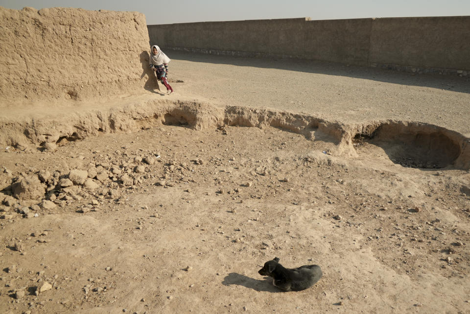 An afghan girl runs on a street at a sprawling settlement of mud brick huts in western Afghanistan housing those displaced by war and drought near Herat, Afghanistan. Dec. 16, 2021. The aid-dependent country’s economy was already teetering when the Taliban seized power in mid-August amid a chaotic withdrawal of U.S. and NATO troops. The consequences have been devastating for a country battered by four decades of war, a punishing drought and the coronavirus pandemic. (AP Photo/Mstyslav Chernov)