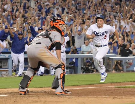 Sep 19, 2016; Los Angeles, CA, USA; Los Angeles Dodgers shortstop Corey Seager (5) scores the winning run on a walk-off double by first baseman Adrian Gonzalez (not pictured) as San Francisco Giants catcher Buster Posey (28) watches at Dodger Stadium. Mandatory Credit: Kirby Lee-USA TODAY Sports