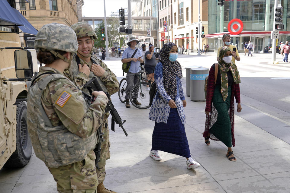 Minnesota National Guard soldiers chat as they stand watch along the famous Nicollet Mall, Thursday, Aug. 27, 2020, in downtown Minneapolis, following vandalism and looting unrest that broke out Wednesday night following what authorities said was misinformation about the suicide of a Black homicide suspect. (AP Photo/Jim Mone)