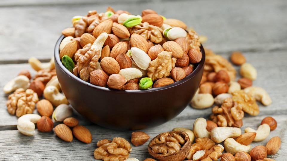 wooden bowl with mixed nuts on a wooden gray background healthy food and snacks, organic vegetarian meals walnut, pistachios, almonds, hazelnuts and cashews, walnut