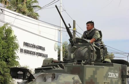 A soldier atop a vehicle is seen outside the Forensic Medical Service (SEMEFO) after the arrival of the body of Francisco Zazueta, also known as "Pancho Chimal," in Culiacan, in Mexico's northern Sinaloa state April 15, 2017. REUTERS/Jesus Bustamante