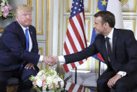 FILE - In this June 6, 2019 file photo, U.S President Donald Trump, left, shakes hands with French President Emmanuel Macron at the Prefecture of Caen, Normandy, France. French President Emmanuel Macron hosts the G-7 summit this weekend fresh off a meeting with Russia's Vladimir Putin, hoping to maintain his image as a global mediator at a time of deep political and economic insecurity in the world and despite President Donald Trump's open disdain for multilateral talks. (Ludovic Marin/POOL via AP, File)