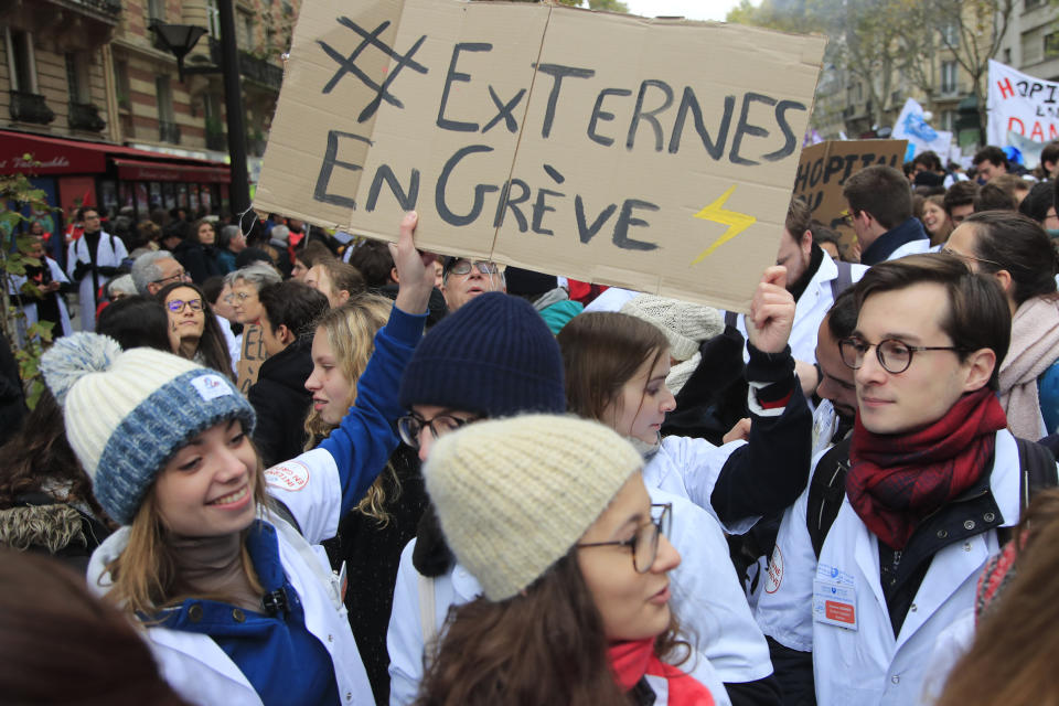 Students doctors showing a poster reading "Striking students" march during a national demonstration Thursday, Nov. 14, 2019 in Paris. Thousands of exasperated nurses, doctors and other public hospital workers are marching through Paris to demand more staff and resources after years of cost cuts. (AP Photo/Michel Euler)