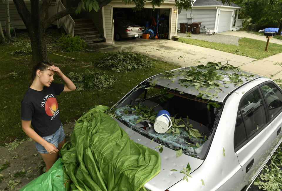 Sara Pilot, left, looks at the hail damage to her father's car outside of her home in Louisville, Colorado, on June 19. (Photo: Helen H. Richardson via Getty Images)