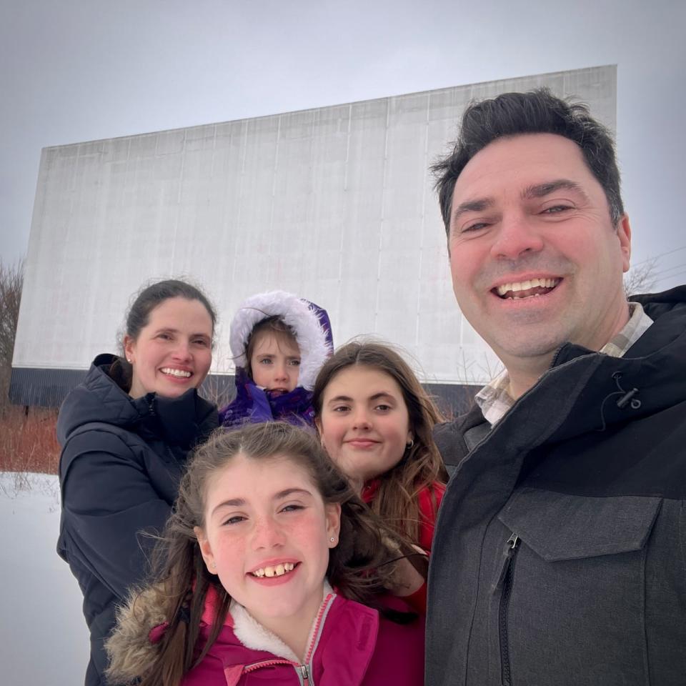 New co-owners Sébastien Després (right) and Heather Wright (left) stand with their kids from in front of the screen of the Shediac Neptune Drive-in theatre. 