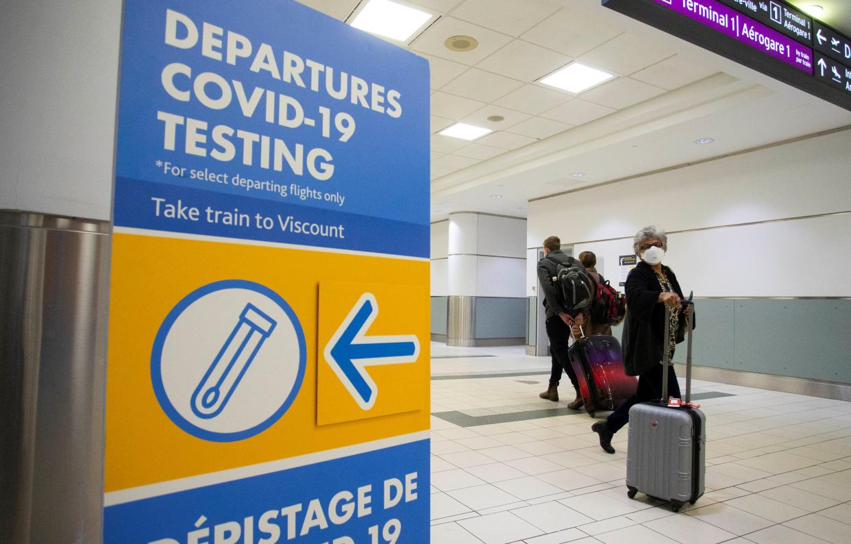 International travelers wearing face masks are seen at the arrival hall of Toronto Pearson International Airport in Mississauga, Ontario, Canada, on Jan. 17, 2022. Canada reported 23,586 new COVID-19 cases Monday evening, raising its national total to 2,801,446 with 30,946 deaths, local media CTV reported. (Photo by Zou Zheng/Xinhua via Getty Images)