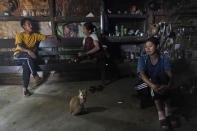 Phonai, left, sits with Awat Wangshu, centre, and her daughter Mary in Phonai's kitchen in Oting village, in the northeastern Indian state of Nagaland, Thursday, Dec. 16, 2021. Awat's 23-year-old son Manpeih was killed by Indian army soldiers on Dec. 4, when he went out as part of a rescue party in search of eight missing villagers, six of whom had already been killed by soldiers. Phonai was also present in the shooting site and barely managed to escape while two people hiding alongside him inside an earthmover were killed. (AP Photo/Yirmiyan Arthur)