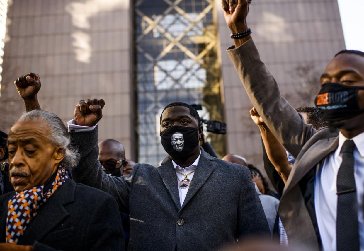 <span class="caption">Floyd's nephew, Brandon Williams (center), with the Rev. Al Sharpton (left) outside the heavily guarded Hennepin County Government Center, in Minneapolis, Minn., before the murder trial of Officer Derek Chauvin began, March 29, 2021.</span> <span class="attribution"><a class="link " href="https://www.gettyimages.com/detail/news-photo/brandon-williams-wears-a-mask-and-pendant-with-the-image-of-news-photo/1232003463?adppopup=true" rel="nofollow noopener" target="_blank" data-ylk="slk:Stephen Maturen/Getty Images;elm:context_link;itc:0;sec:content-canvas">Stephen Maturen/Getty Images</a></span>