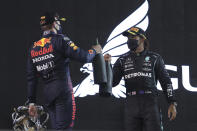 Winner, Mercedes driver Lewis Hamilton of Britain, right, celebrates with Red Bull driver Max Verstappen of the Netherlands, second place, on the podium after the Bahrain Formula One Grand Prix at the Bahrain International Circuit in Sakhir, Bahrain, Sunday, March 28, 2021. (AP Photo/Kamran Jebreili)