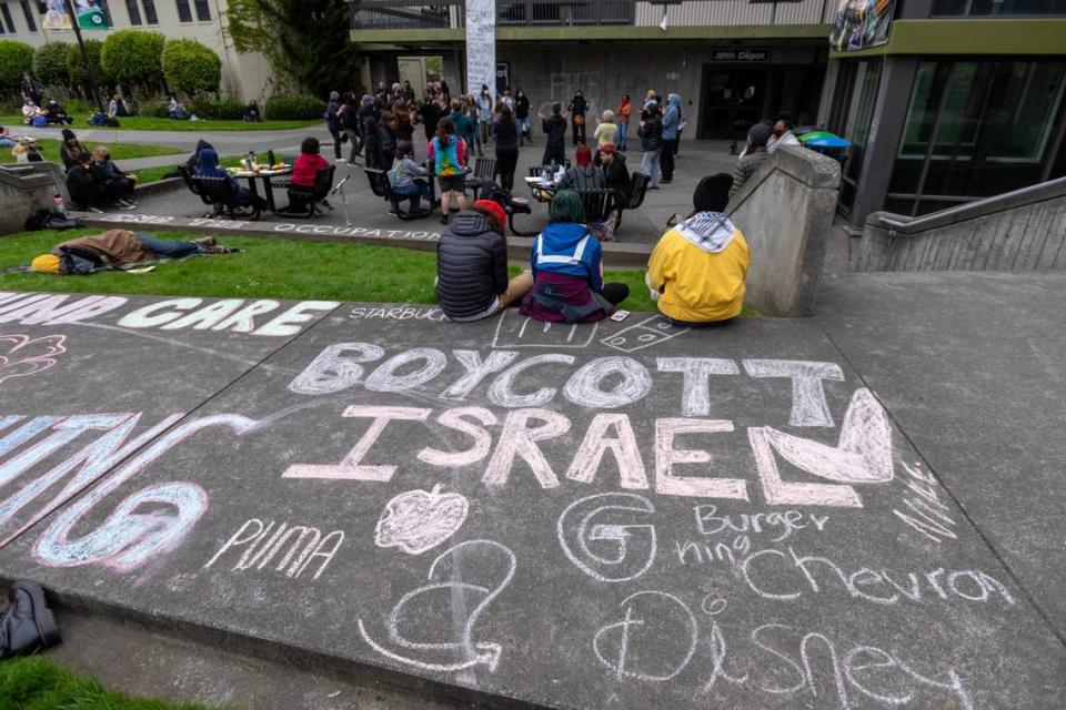 Chalk writing covers the sidewalk as students and community members gather outside Siemens Hall at Cal Poly Humboldt in Arcata on April 23 to support pro-Palestinian demonstrators who have barricaded themselves inside an administrative building the day before.