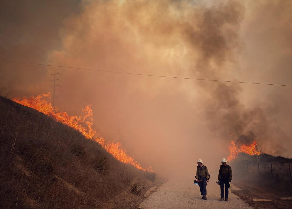 This Tuesday Oct. 12, 2021, photo provided by Santa Barbara County Fire, Santa Barbara County Fire Hand Crew members fight fire with fire and burn off pockets of grass along northbound Highway 101 north of Arroyo Hondo Canyon in Santa Barbara County, Calif.  / Credit: Mike Eliason / AP