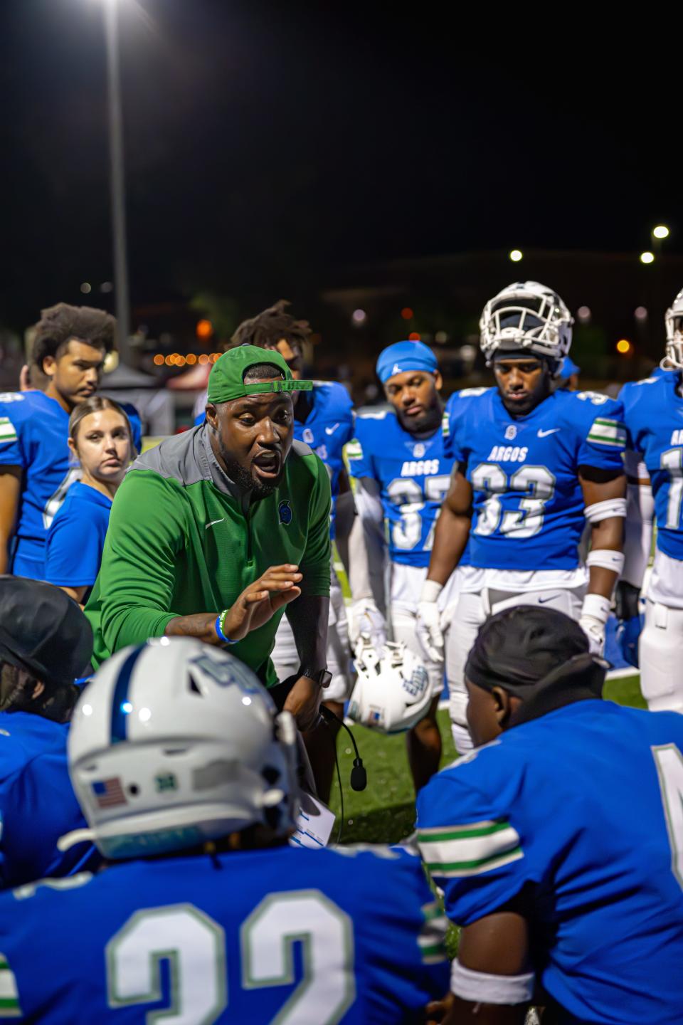 University of West Florida football coach Kavell Conner (green hat), the defensive coordinator for the team, talks to players during a recent game.