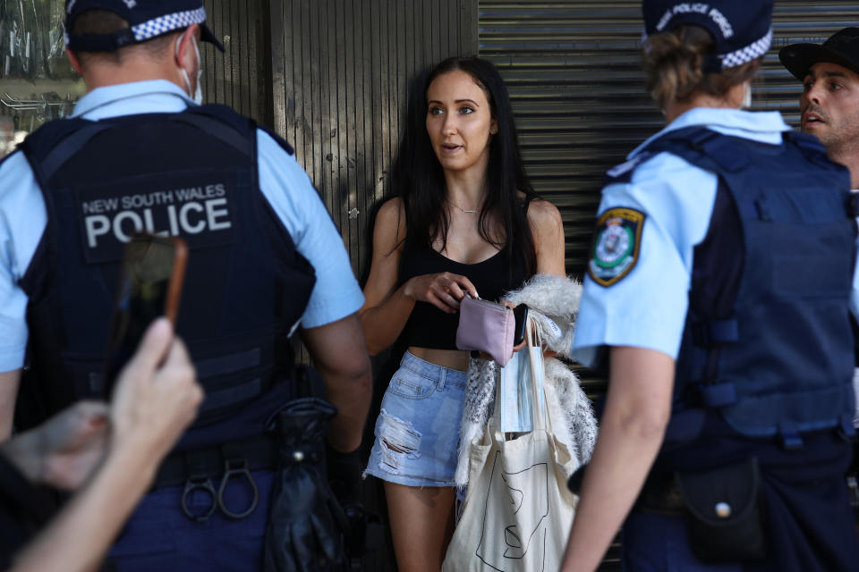 A woman is questioned by NSW Police on Broadway on Saturday during anti-lockdown protests. Source: Getty