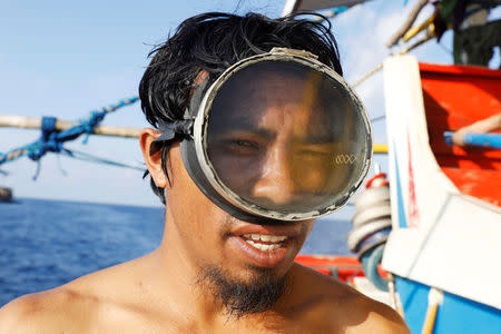 A Philippine fisherman wearing a makeshift goggles poses on on a boat at the disputed Scarborough Shoal April 6, 2017. Picture taken April 6, 2017. REUTERS/Erik De Castro