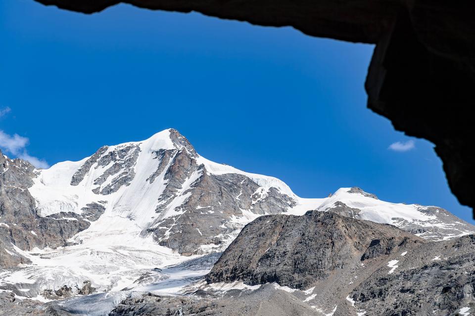 From inside a cave, the peak of Gran Paradiso, Alps landscape