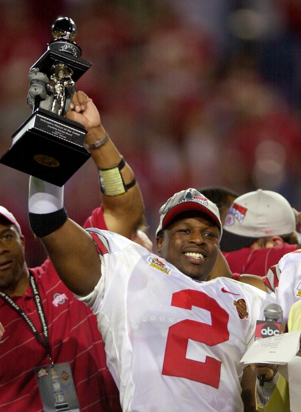 Ohio State's Michael Doss raises the defensive MVP trophy after the Buckeyes beat Miami 31-24 to win the Fiesta Bowl and national championship in Tempe, Ariz. Friday, Jan. 3, 2003.