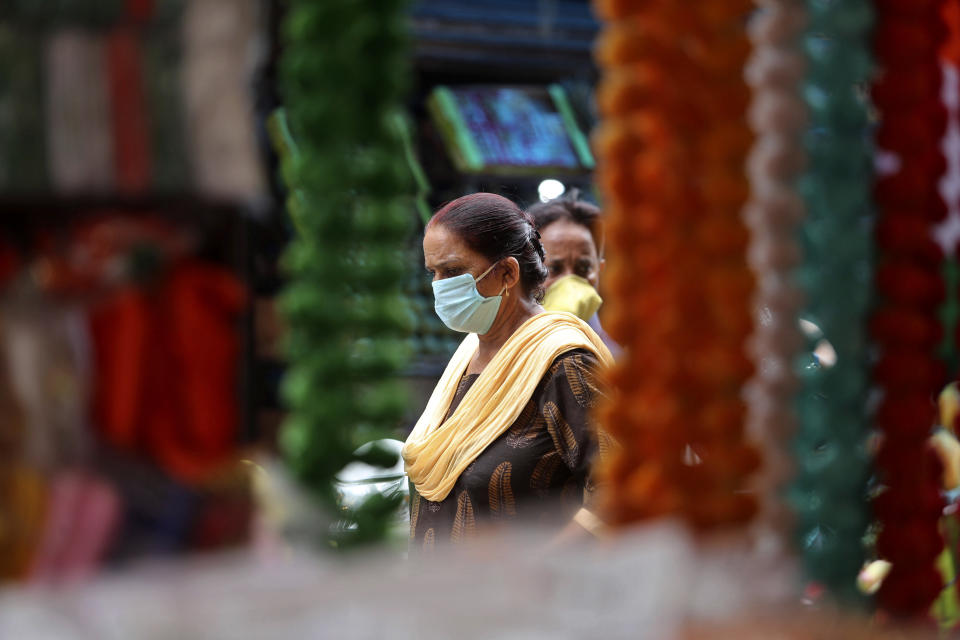 Women wearing face masks as a precaution against the coronavirus walk at market in Jammu, India, Thursday, Aug 6, 2020. India is the third hardest-hit country by the pandemic in the world after the United States and Brazil. (AP Photo/Channi Anand)