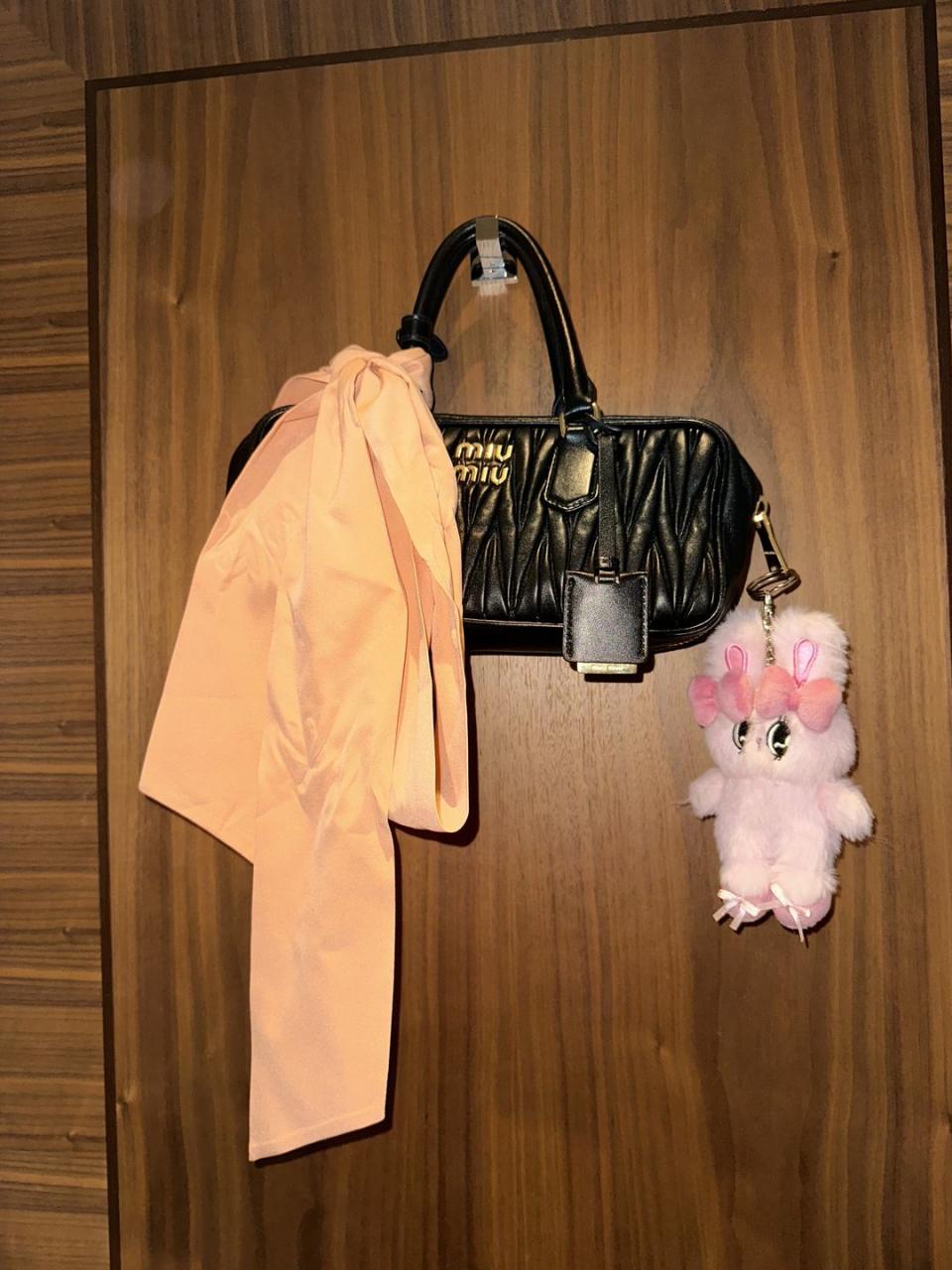 a pink stuffed animal next to a bag and a pink stuffed animal