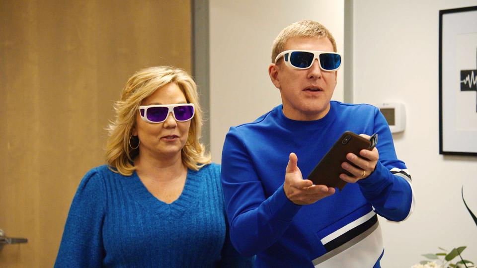 Todd and Julie Chrisley wear sunglasses and blue sweaters.