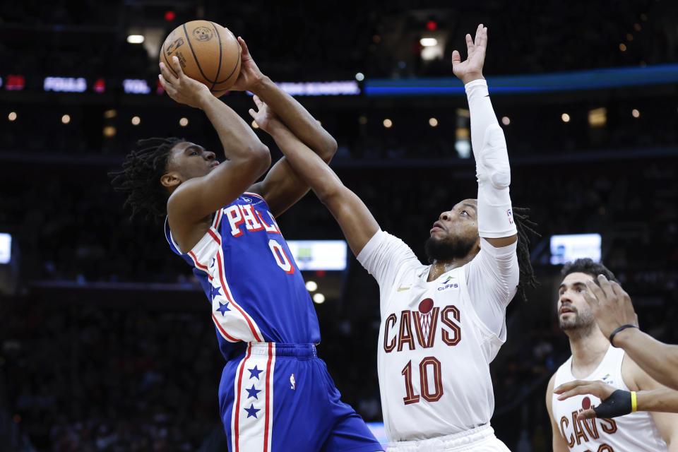 Philadelphia 76ers guard Tyrese Maxey (0) shoots against Cleveland Cavaliers guard Darius Garland (10) during the first half of an NBA basketball game Friday, March 29, 2024, in Cleveland. (AP Photo/Ron Schwane)