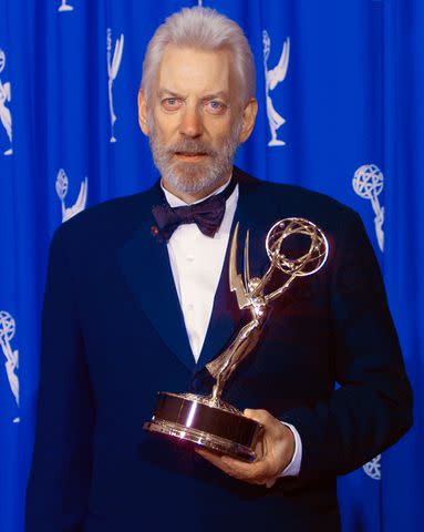 <p>Bob Riha Jr./Getty</p> Donald Sutherland wins an Emmy in 1995