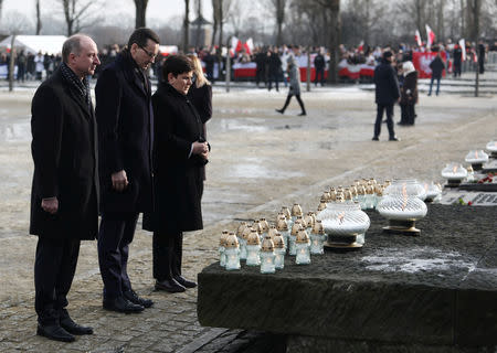 Polish Prime Minister Mateusz Morawiecki, deputy Prime Minister Beata Szydlo and Undersecretary of State at the Chancellery of the President of Poland Wojciech Kolarski place candles at the Monument to the Victims during a commemoration event at the former Nazi German concentration and extermination camp Auschwitz II-Birkenau, during the ceremonies marking the 74th anniversary of the liberation of the camp and International Holocaust Victims Remembrance Day, near Oswiecim, Poland, January 27, 2019. Agencja Gazeta/Jakub Porzycki via REUTERS