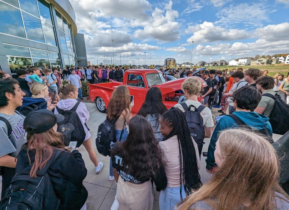 Liberty High school students flocked around the pristine 1953 Chevy pickup displayed by Dennis Hegland of Coralville under sunny skies last week. Hegland added spice to the experience by revving the engine, the roar echoing off the school’s back walls.