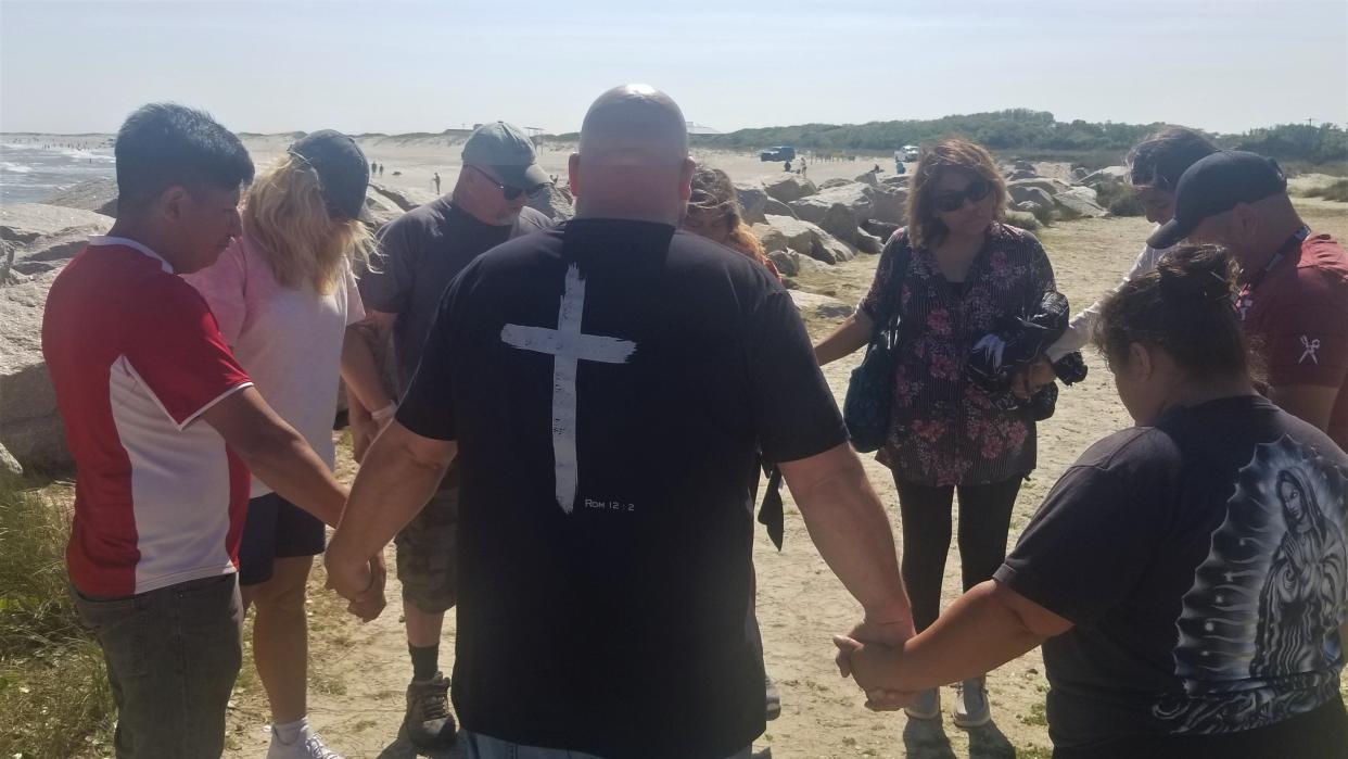 Wesley Bullard, pastor at Bridge of Life Community Church, led a prayer with family and friends of David Hernandez. The teenager went missing Saturday while swimming at Fort Fisher.