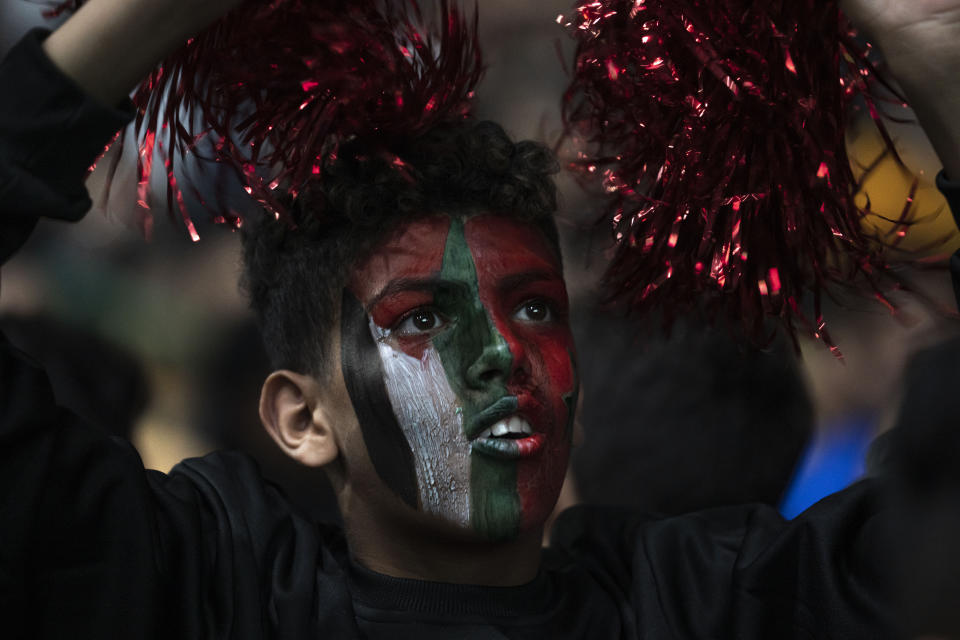 A Morocco fan with his face painted with Moroccan and Palestinian flags watches a live broadcast of the World Cup quarterfinal soccer match between Morocco and Portugal on Saturday in Gaza City. (AP Photo/Fatima Shbair)