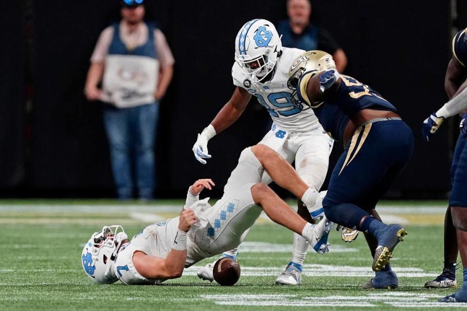 North Carolina quarterback Sam Howell (7) loses the ball after being hit by Georgia Tech defensive lineman Ja’Quon Griffin (95) during the first half of an NCAA college football game Saturday, Sept. 25, 2021, in Atlanta. Murphy recovered his fumble. (AP Photo/John Bazemore)