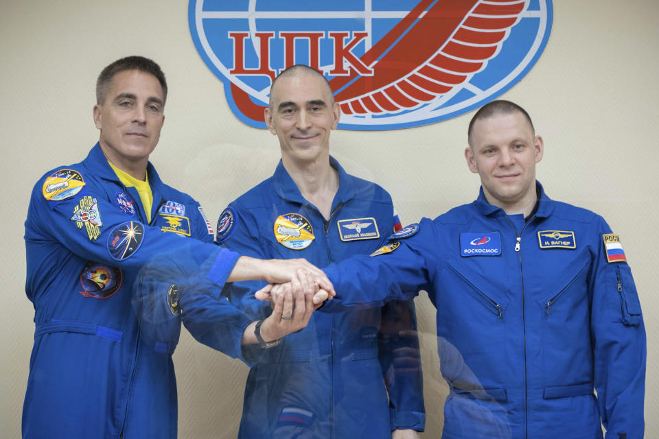 In this handout photo released by Roscosmos U.S. astronaut Chris Cassidy, left, Russian cosmonauts Anatoly Ivanishin, centre, and Ivan Vagner, members of the main crew to the International Space Station (ISS), pose during a news conference at the Baikonur Cosmodrome, Kazakhstan, Wednesday, April 8, 2020. The new Soyuz mission to the International Space Station is scheduled on Thursday, April 9. (Roscosmos Space Agency Press Service via AP)