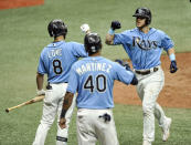 Tampa Bay Rays' Brandon Lowe (8) and Jose Martinez (40) congratulate Michael Brosseau, right, after his two-run home run off New York Yankees starter James Paxton during the seventh inning of a baseball game Sunday, Aug. 9, 2020, in St. Petersburg, Fla. (AP Photo/Steve Nesius)