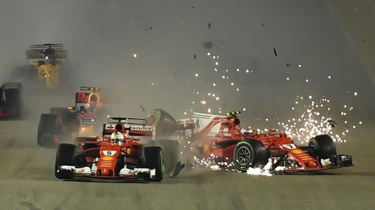 The car of Ferrari's driver Kimi Raikkonen (R) crashes as Ferrari's driver Sebastian Vettel leads during the Singapore Grand Prix on September 17, 2017