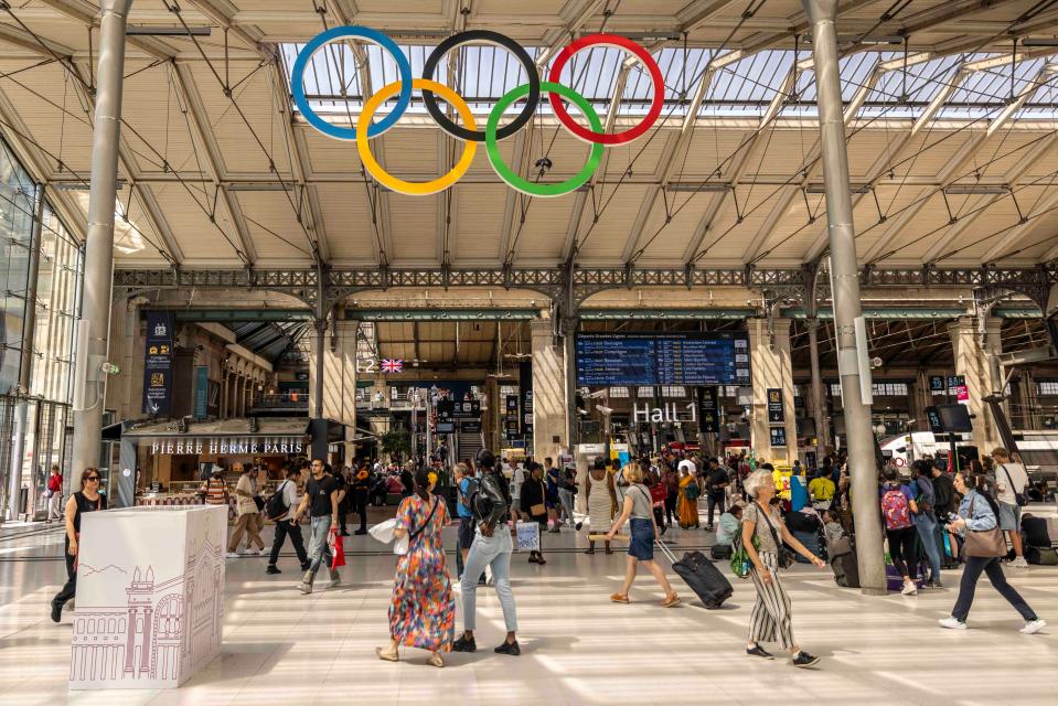 Olympic rings are seen as visitors walk at the Gare du Nord station on July 19, 2024 in Paris, France. Businesses, travel companies and Microsoft users across the globe were among those affected by a tech outage today.