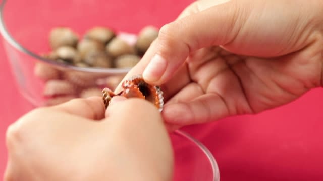 Pulling a cockle shell open with fingers