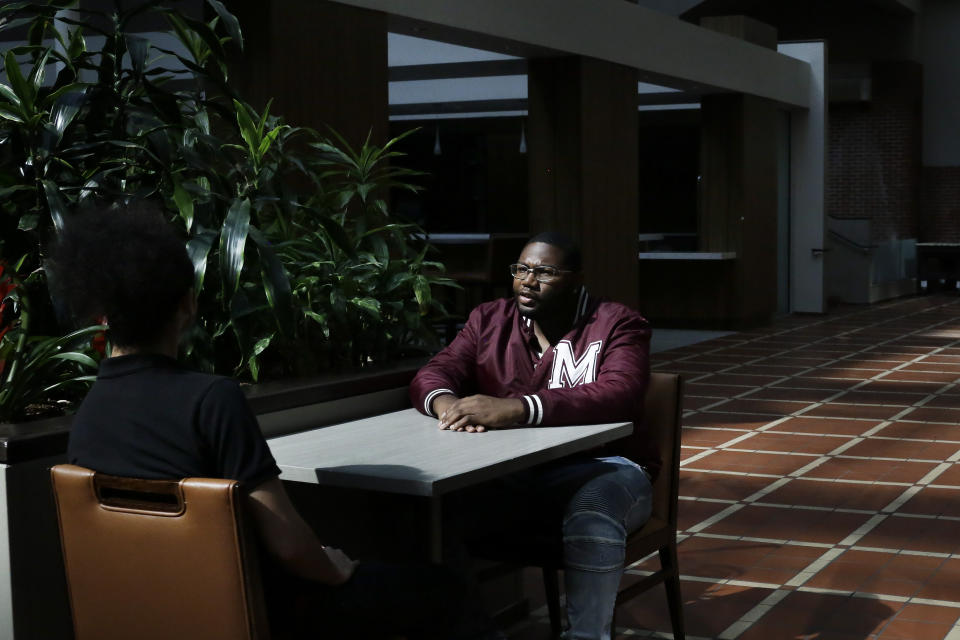 In this Tuesday, May 5, 2020, photo, Morehouse College senior Lanarion "LTL" Norwood Jr., of Atlanta, sits and talks with fellow student Joseph Ramirez in a hotel in Atlanta. Students were sent home from the college amid the new coronavirus outbreak. (AP Photo/Brynn Anderson)