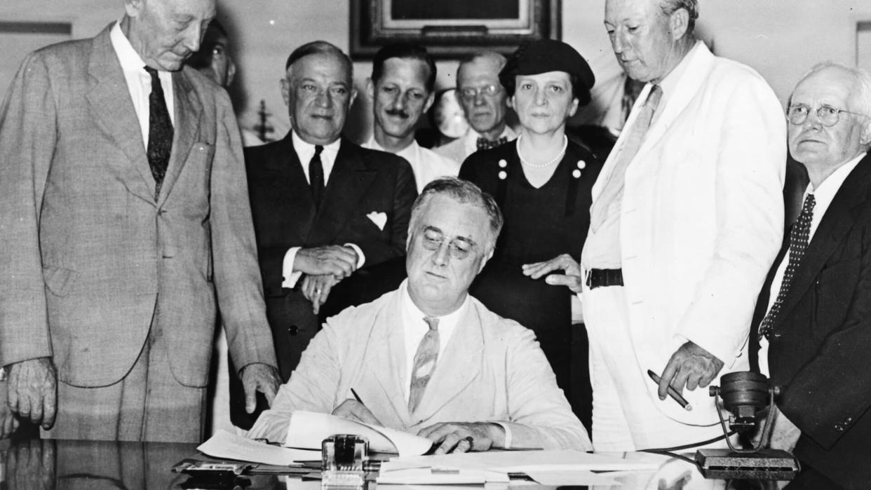 Roosevelt signs Social Security Act on August 14, 1935