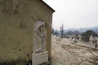 A burnt cemetery during a wildfire in Kirinthos village on the island of Evia, about 135 kilometers (84 miles) north of Athens, Greece, Friday, Aug. 6, 2021. Thousands of people fled wildfires burning out of control in Greece and Turkey on Friday, including a major blaze just north of the Greek capital of Athens that claimed one life, as a protracted heat wave left forests tinder-dry and flames threatened populated areas and electricity installations. (AP Photo/Thodoris Nikolaou)