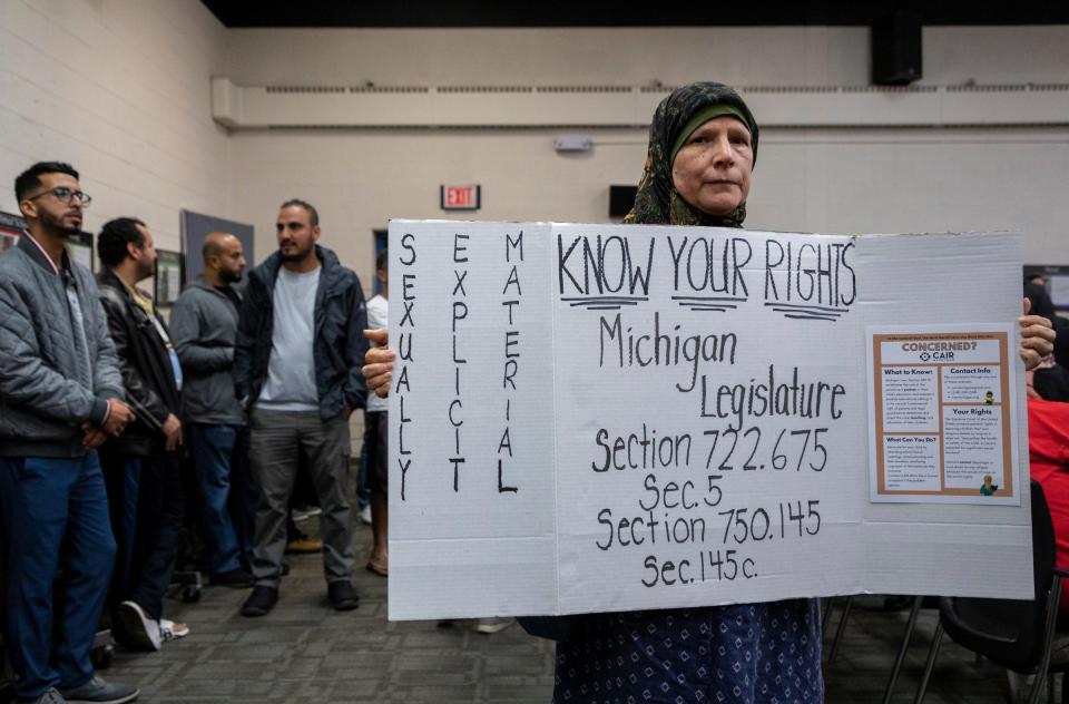 Marion Mourtada, a Dearborn resident and grandmother of a Dearborn Public School student, holds a sign during the Dearborn Board of Education meeting in Dearborn on Oct. 10, 2022.